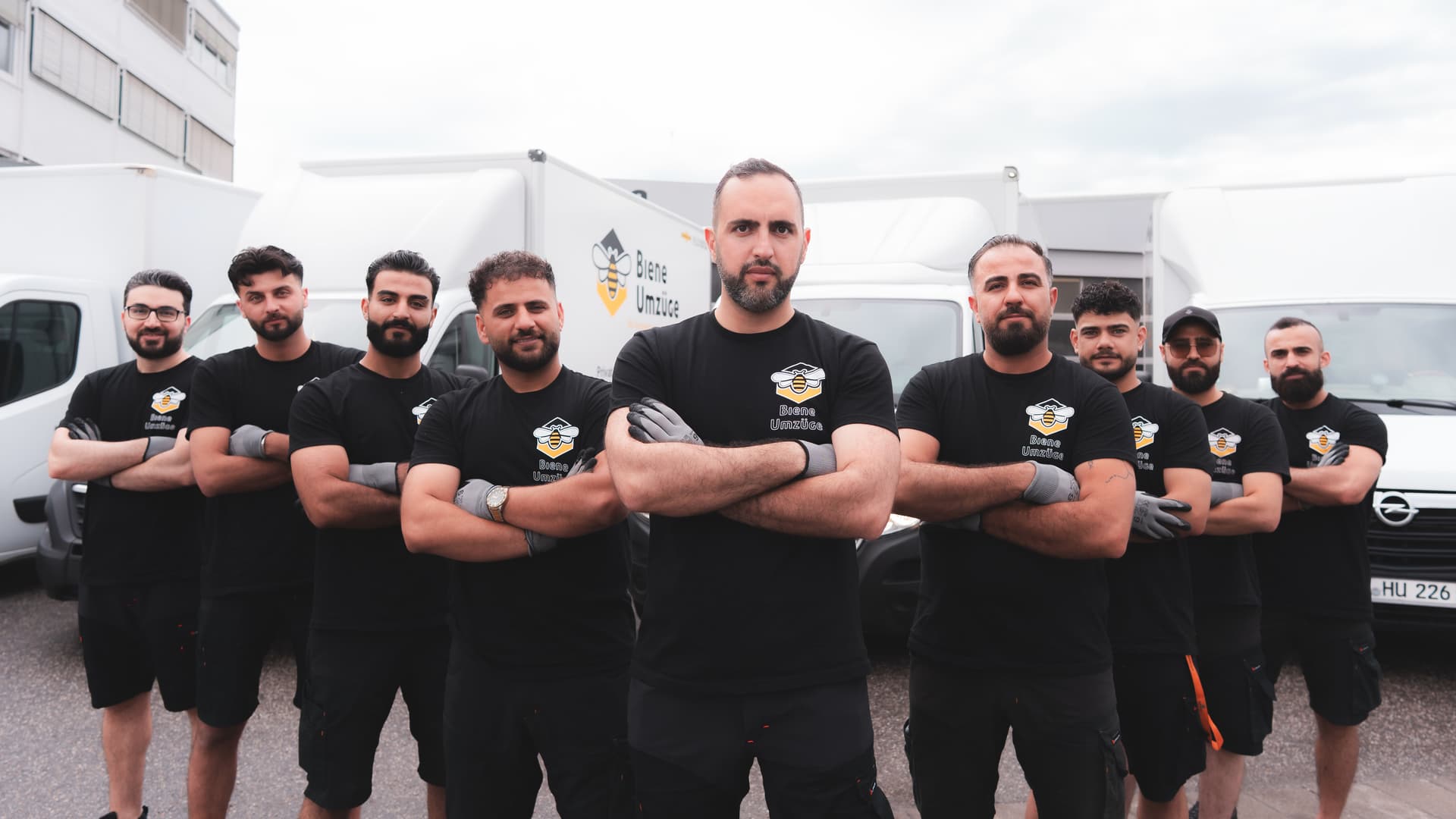 Team von Biene Umzüge vor mehreren Firmenfahrzeugen